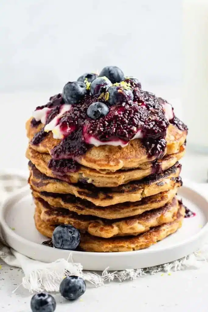 Delicious lemon blueberry pancakes stacked with fresh berries on top