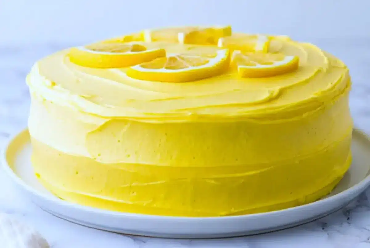 Freshly baked lemon cake with frosting on a wooden table