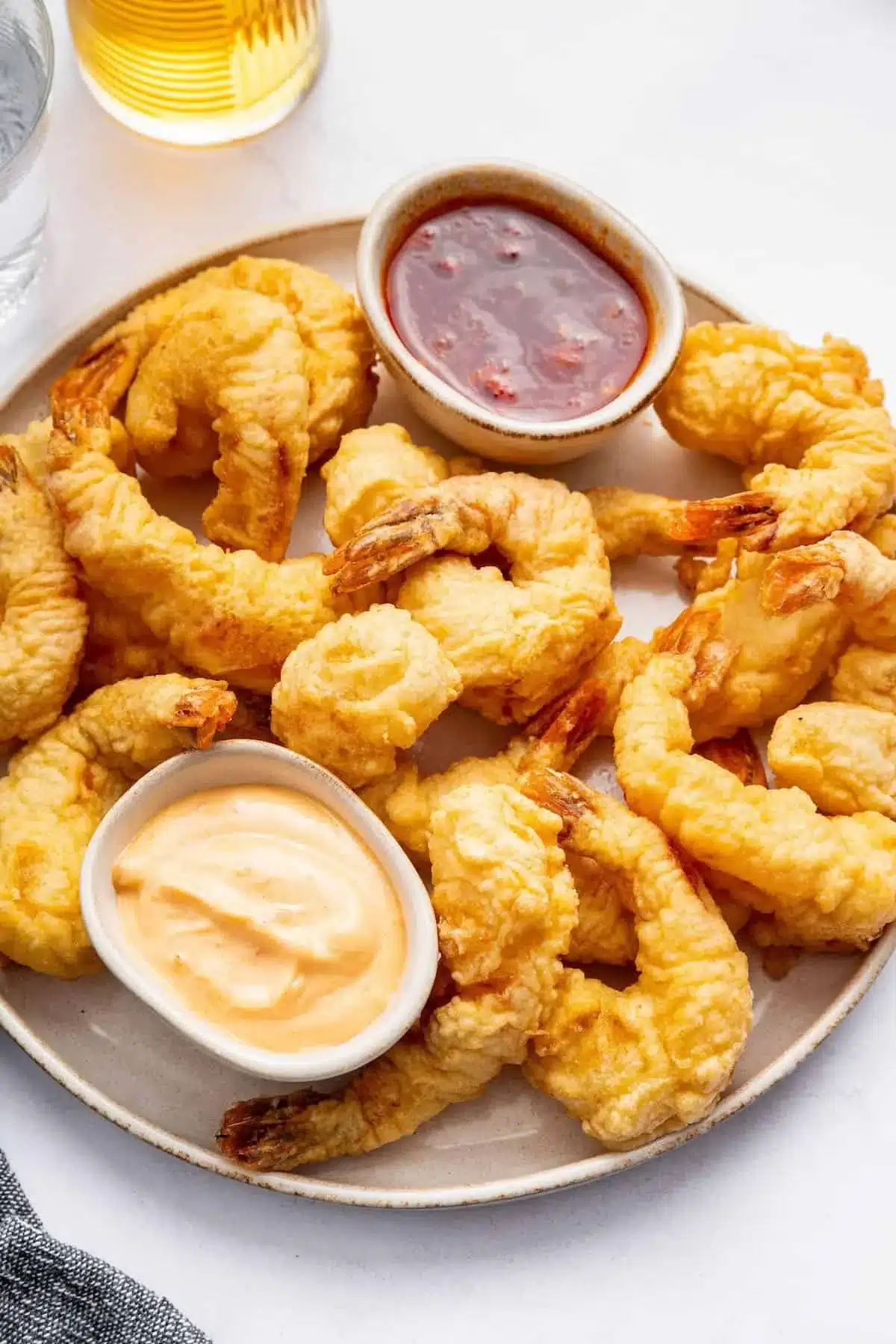 Crispy shrimp tempura served with dipping sauce on a plate