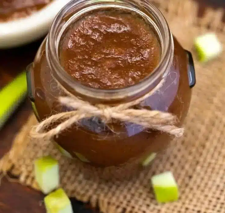 Jar of homemade slow cooker apple butter with fresh apples