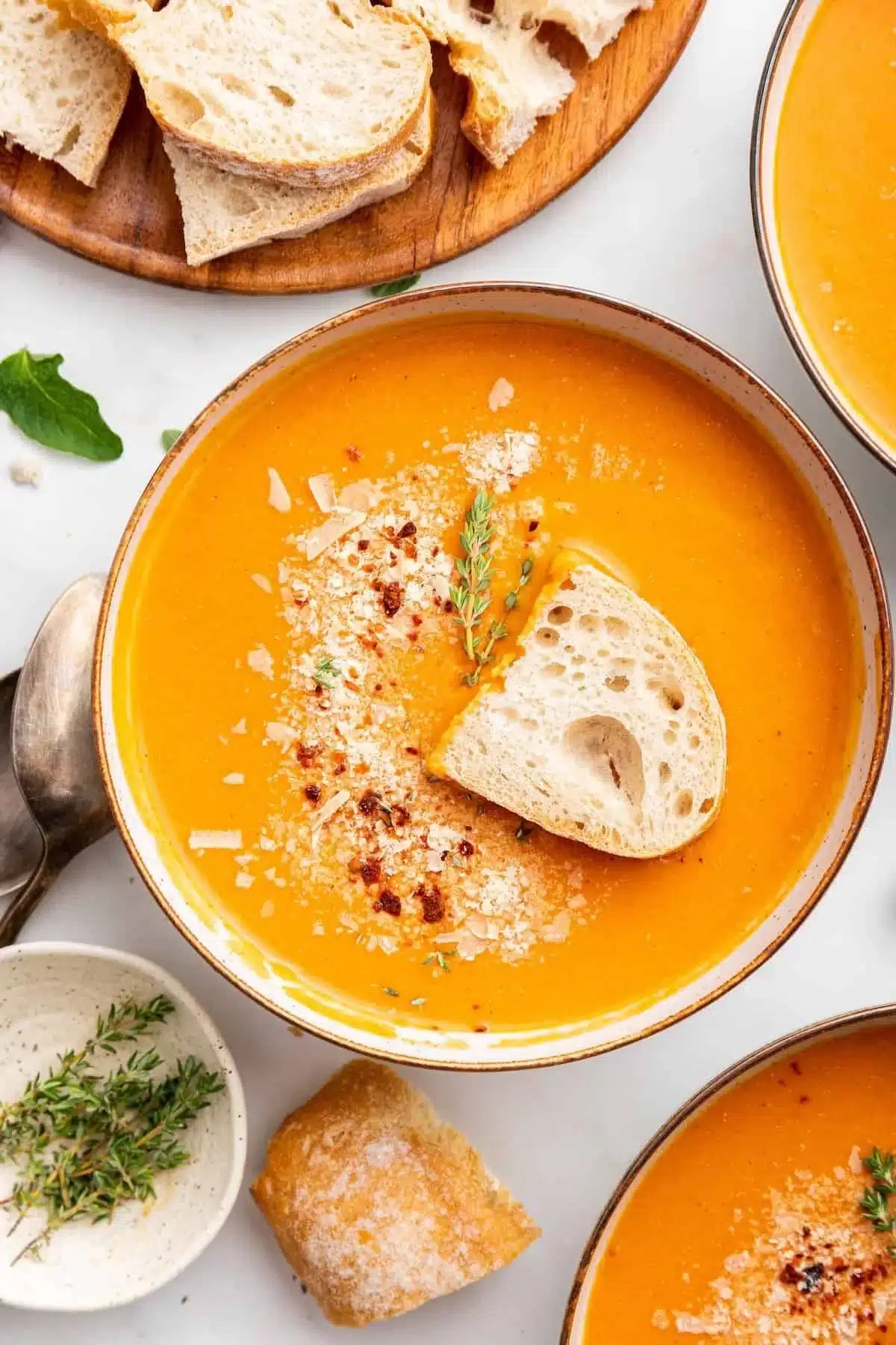 Bowl of creamy tomato bisque soup garnished with fresh herbs