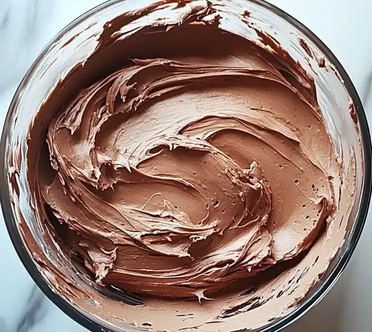Delicious chocolate buttercream frosting in a mixing bowl