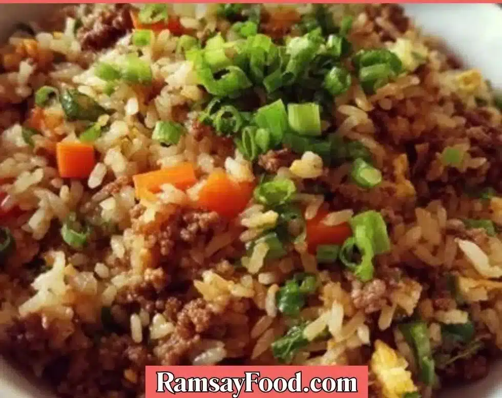 Plate of ground beef fried rice garnished with vegetables and herbs